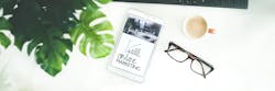 Online marketing on phone with Brown Framed Eyeglasses on desk