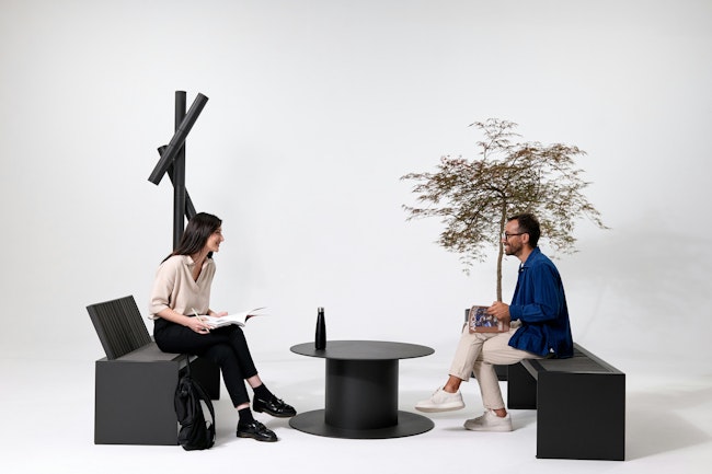Two people sitting on outdoor furniture in front of white background